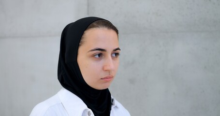 Muslim woman in hijab displaying varied facial expressions from contemplative to intense, standing...