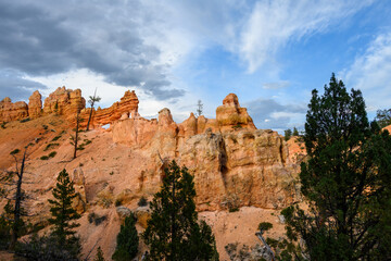 Scenic ridgeline at twilight with beautiful orange rock formations and ponderosa pine trees, Mossy Cave Trail, Bryce Canyon National Park, Utah
