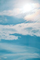 Obraz premium Bright blue sky with white clouds and glowing sun for background, texture, nature and design concepts, 눈부신 태양과 흰 구름의 파란 하늘 배경, 텍스처, 자연, 디자인 콘셉트 활용