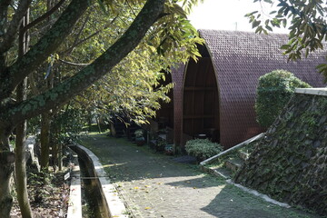 Serene pathway leading to wooden building with lush greenery