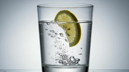 Refreshing lemon slice in sparkling water glass - Powered by Adobe