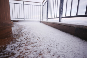 Snow covers wooden balcony in winter morning light