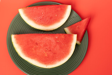 Slices of refreshing watermelon arranged on a green plate for a summer treat