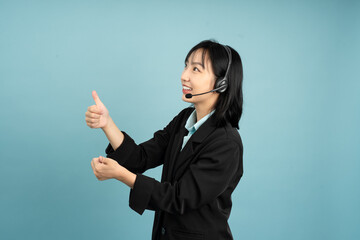 Young Asian professional wearing headset gestures positively while conducting a virtual meeting in...