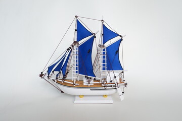 Miniature of a Traditional sailing boat made from wood and has blue sail