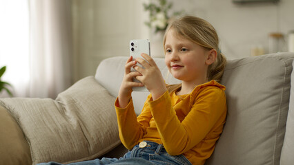 Little European girl user mobile phone smartphone cellphone online child chat networking browser...