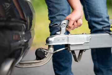Attach a trailer to the car close up. Locking the lever of the Hitch coupling to connect to the...
