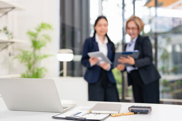 Two asian business persons working together. Businessman brainstorming, having a discussion with...
