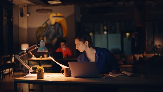Overloaded entrepreneur reading papers at laptop workplace. Tired businesswoman 