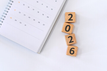 Calendar on notebook and 2026 written on wooden blocks. New year 2026 concept. New year's...