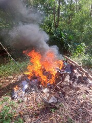 Sungai Petani, Kedah, Malaysia – July 5, 2025 – A pile of mixed trash burning in an open field...