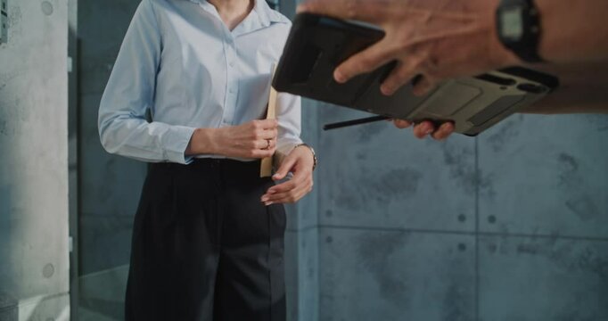 Close Up of Postman Delivering Small Parcel for Addressee in Office, Getting Client's Signature on Digital Tablet. Businesswoman Taking Padded Envelope with Online Shopping Order. Delivery Service.