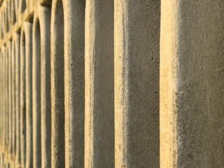 Close-up of textured stone wall with repeating patterns in sunlight