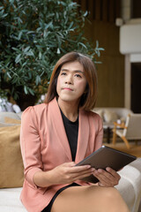 Confident transgender non binary person in smart business attire at stylish indoor cafe restaurant