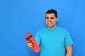 40-year-old dark-skinned Latino man shows his plastic bottle to carry water and avoid waste