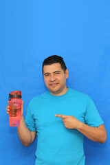 40-year-old dark-skinned Latino man shows his plastic bottle to carry water and avoid waste