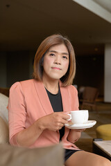 Confident transgender non binary person in smart business attire at stylish indoor cafe restaurant