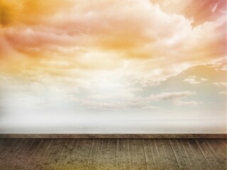 Wide wooden deck leading into calm ocean under pastel cloud sky being shown in flat design