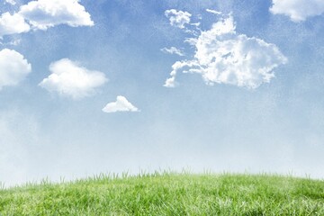 Grassy hill against cloudy sky