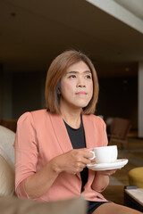 Confident transgender non binary person in smart business attire at stylish indoor cafe restaurant