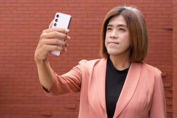 Confident transgender non binary person in smart business attire against plain background