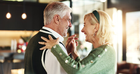 Happy, senior couple and dancing on Christmas for love, romance or season in home. Holding hands, marriage and elderly people with smile in lounge for festive holiday, relationship or bonding