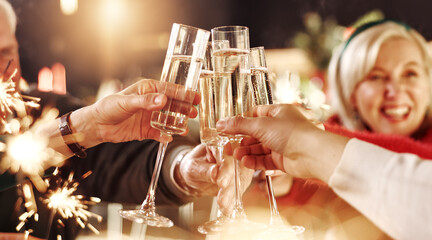Happy family, hands and cheers with champagne glasses for thanksgiving dinner, toast or home feast. People, alcohol or drink with sparklers for dining celebration, festive holiday or christmas party