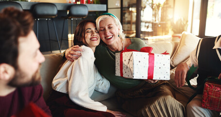 Hug, Christmas gift and woman with senior parent for vacation, bonding and excited. December,...