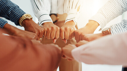 Business people, hands and fist in huddle with support, collaboration or team building. United, staff mission or group of employees with circle in office for synergy, meeting or solidarity together