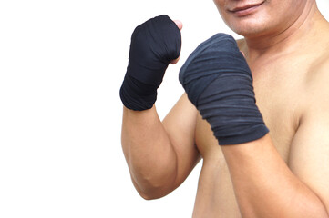 Close-up Thai male boxer’s clenched fists wrapped in black hand wraps. Concept strength,...