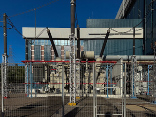 Cilegon, Indonesia-October 26, 2024: Electrical substation with high-voltage power lines and transformers against a clear blue sky, demonstrating power generation infrastructure.