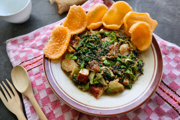 lotek is a traditional salad from Indonesia made from vegetable, chayote, kale, young jackfruit, tempeh, tofu, long beans, and bean sprouts with peanut sauce and cracker