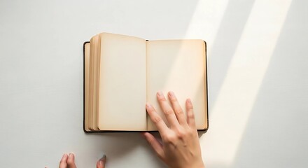 A hand holding an open notebook
