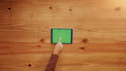 Green screen, tablet and hands of businesswoman in office for research, email or networking. Chroma key, pointing and team of corporate employee with digital technology for communication by table.