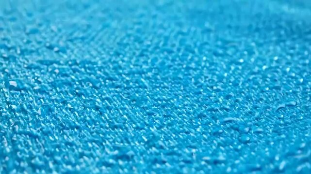 Close-up of a vibrant blue textured surface with small raised dots, showing a detailed pattern of a synthetic material