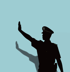 Silhouette of a male police officer signaling with an outstretched hand.