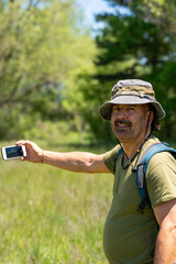 Hiker taking a selfie looking at the camera in a forest