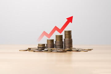 Stacked coins with rising red arrow representing inflation concept, increasing cost of living, economic pressure, financial instability, money depreciation, and macroeconomic inflation trend