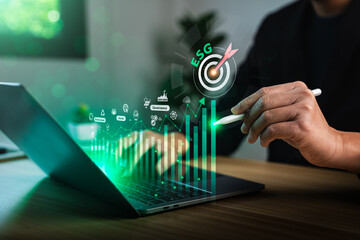 Businessman analyzing ESG data on digital interface with bar chart, environmental icons and...