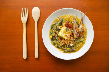 bubur manado or Tinutuan Porridge is tradisional porridge. Manadonese rice porridge, mixed with pumpkin, corn, vegetables. Served with tofu salted fish and chili sauce or sambal