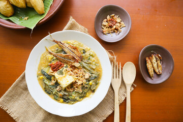 bubur manado or Tinutuan Porridge is tradisional porridge. Manadonese rice porridge, mixed with pumpkin, corn, vegetables. Served with tofu salted fish and chili sauce or sambal