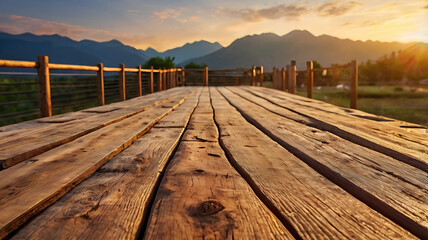 A wooden walkway leading toward a mountain range at sunset. Blurred background for text placement. Natural golden lighting. 
