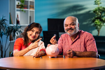 Elderly Indian couple managing savings with coins and piggy bank, planning secure financial future