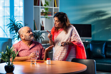 Elderly Indian couple taking medicine and managing health with daily medication and care routine