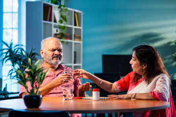 Elderly Indian couple taking medicine and managing health with daily medication and care routine