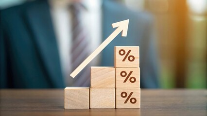 Defocused economic setting highlighting upward arrow and percentage sign on wooden blocks for mortgage growth
