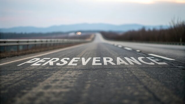 Blurred highway stretching into distance with bold “Perseverance ” text painted on road surface