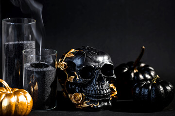 Halloween celebration. Black skull with golden roses, pumpkins, and black candles. Decor for the...