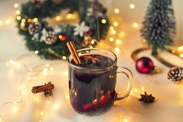 A photo of a steaming bowl of mulled wine served with apples and orange slices
