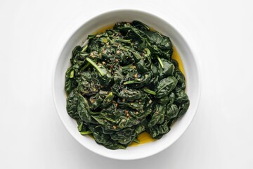 A photo of cooked spinach in a white bowl.